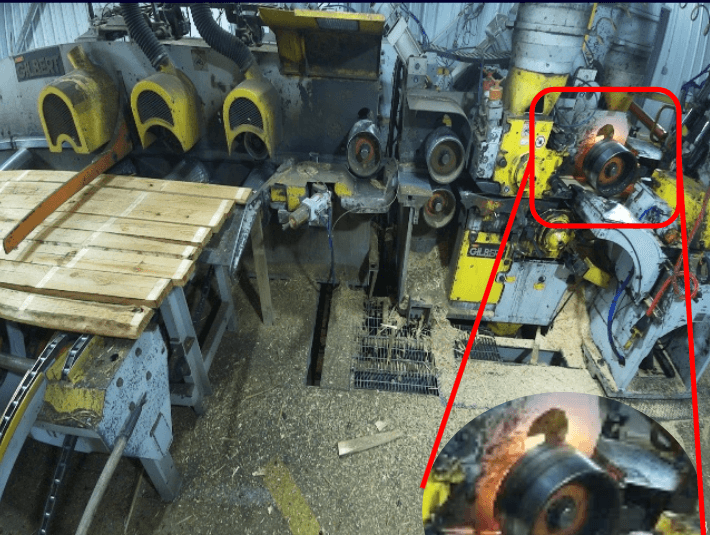 AVIAN thermal camera image showing fire starting behind an outfeed roller on an industrial planer, with orange and red thermal signature visible on the outfeed section of the planer machine